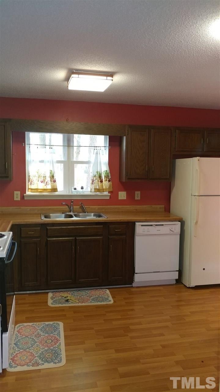 5742 Pool Side Drive Raleigh, NC 27612 - Photo 5 of 13 a kitchen with stainless steel appliances granite countertop a sink and cabinets with wooden floor