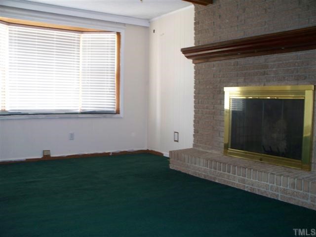 2824 Poole Road Raleigh, NC 27610 - Photo 6 of 12 a view of an empty room with wooden floor and a window