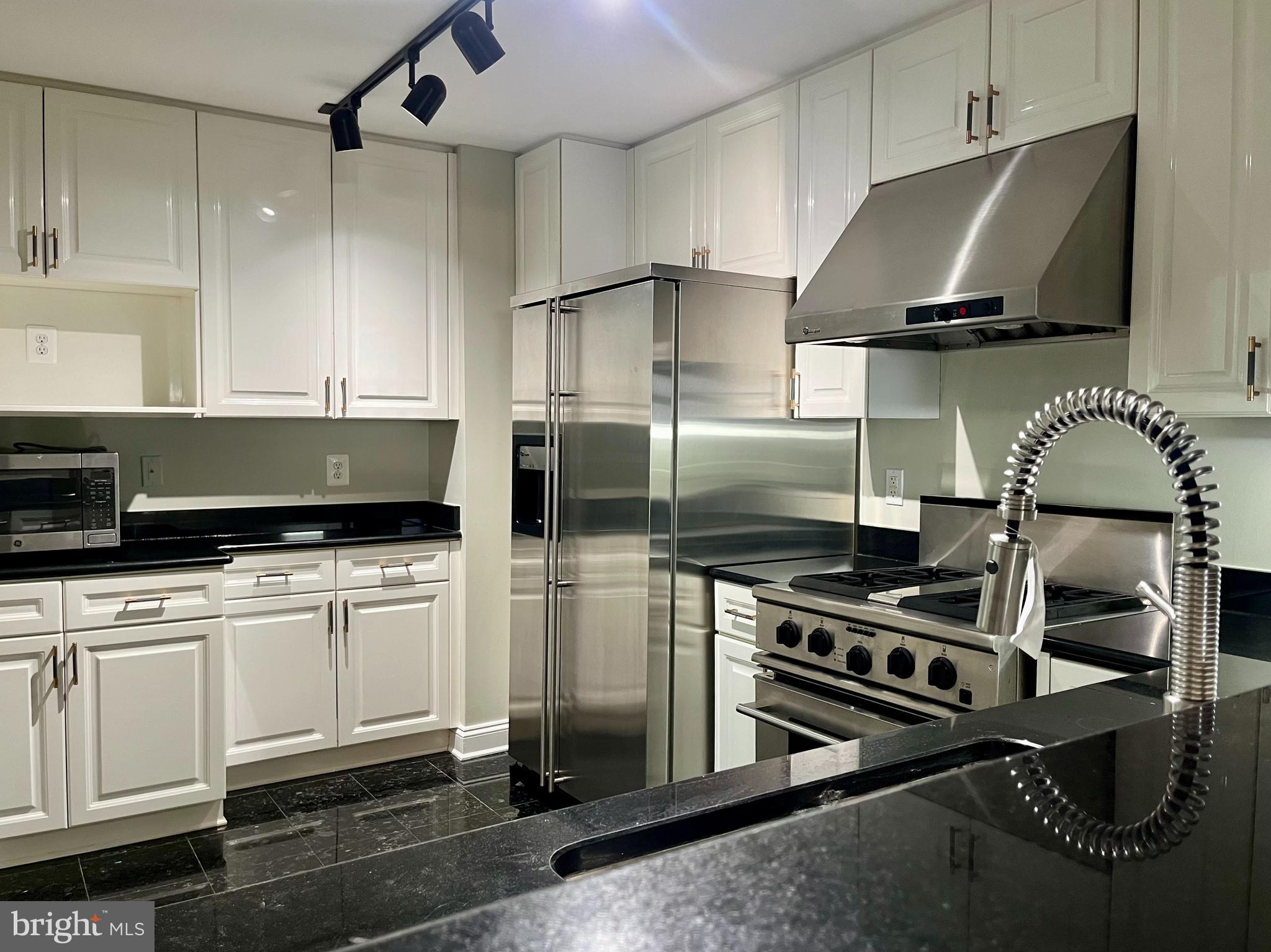 11776 Stratford House Place, Unit 1205 Reston, VA 20190 - Photo 3 of 16 a kitchen with stainless steel appliances granite countertop a stove a sink and a refrigerator