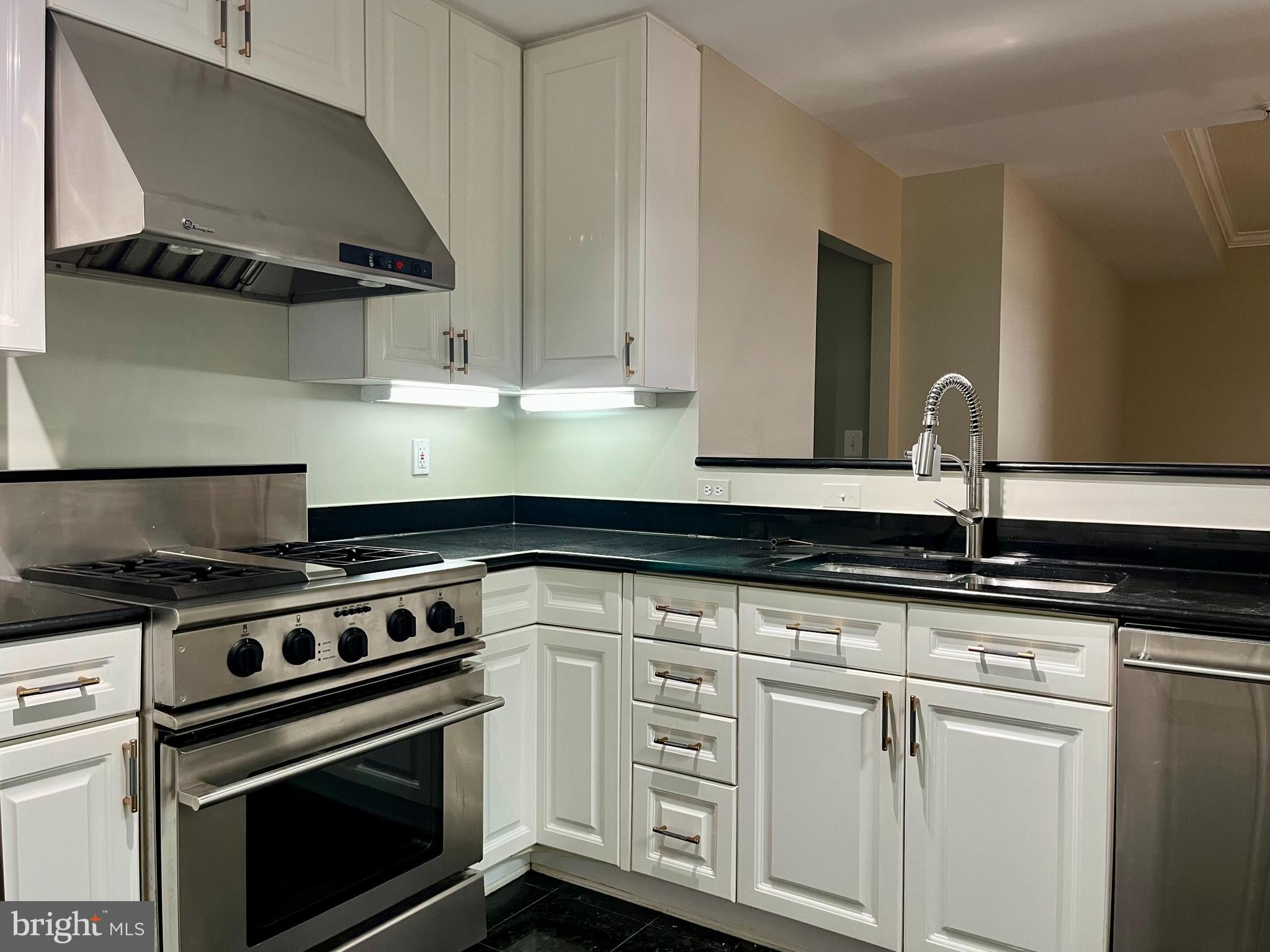 11776 Stratford House Place, Unit 1205 Reston, VA 20190 - Photo 4 of 16 a kitchen with white cabinets and appliances
