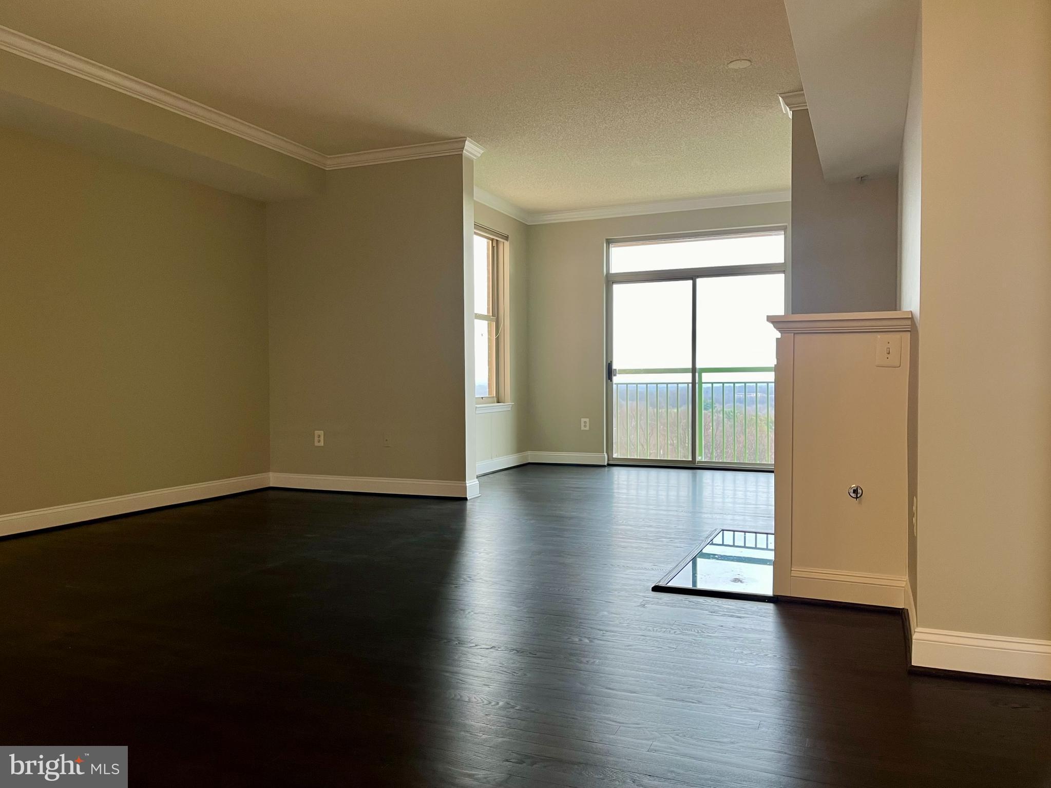 11776 Stratford House Place, Unit 1205 Reston, VA 20190 - Photo 5 of 16 an empty room with wooden floor and windows