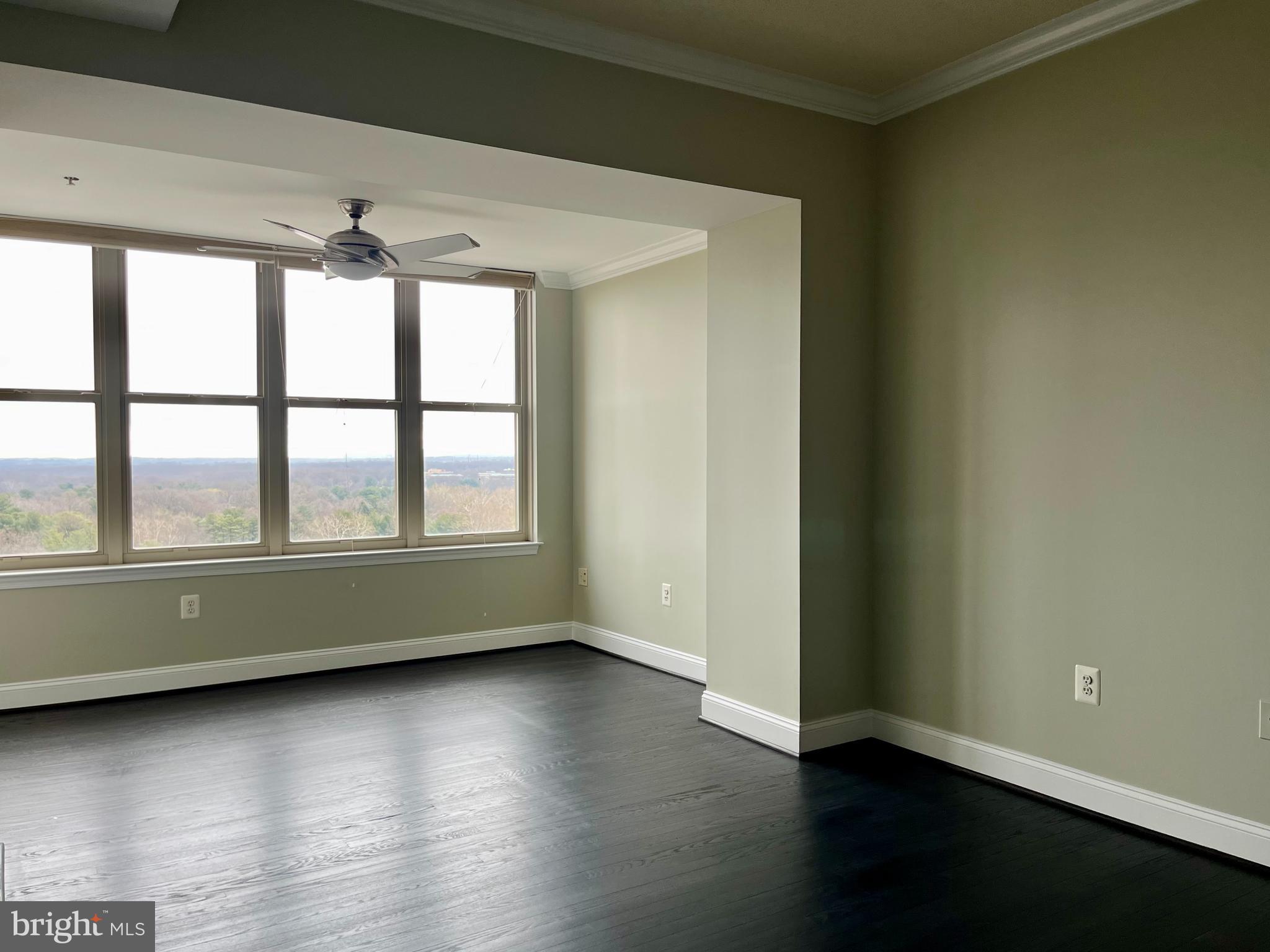 11776 Stratford House Place, Unit 1205 Reston, VA 20190 - Photo 8 of 16 an empty room with wooden floor and windows