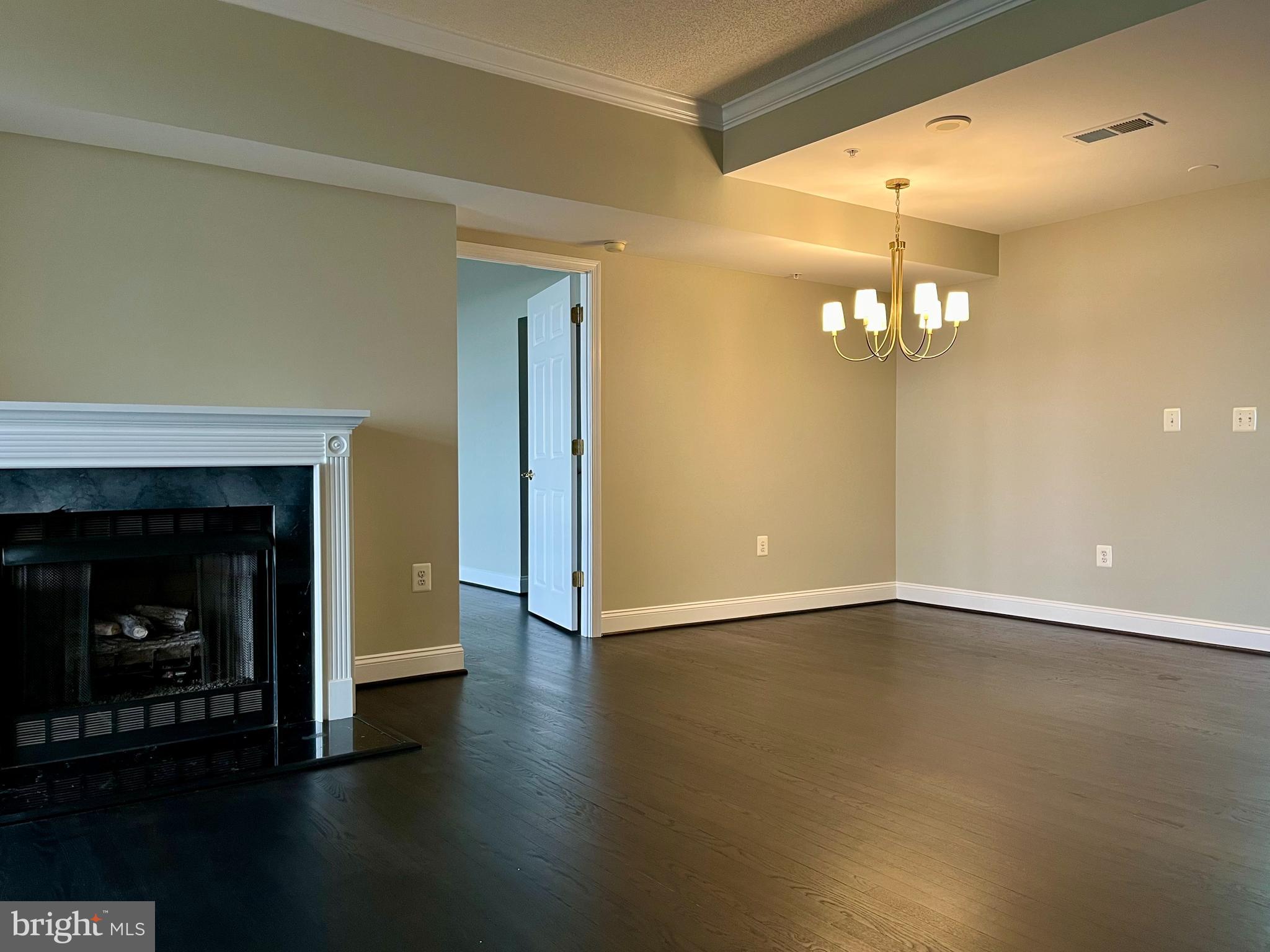 11776 Stratford House Place, Unit 1205 Reston, VA 20190 - Photo 9 of 16 a view of an empty room with wooden floor and a fireplace