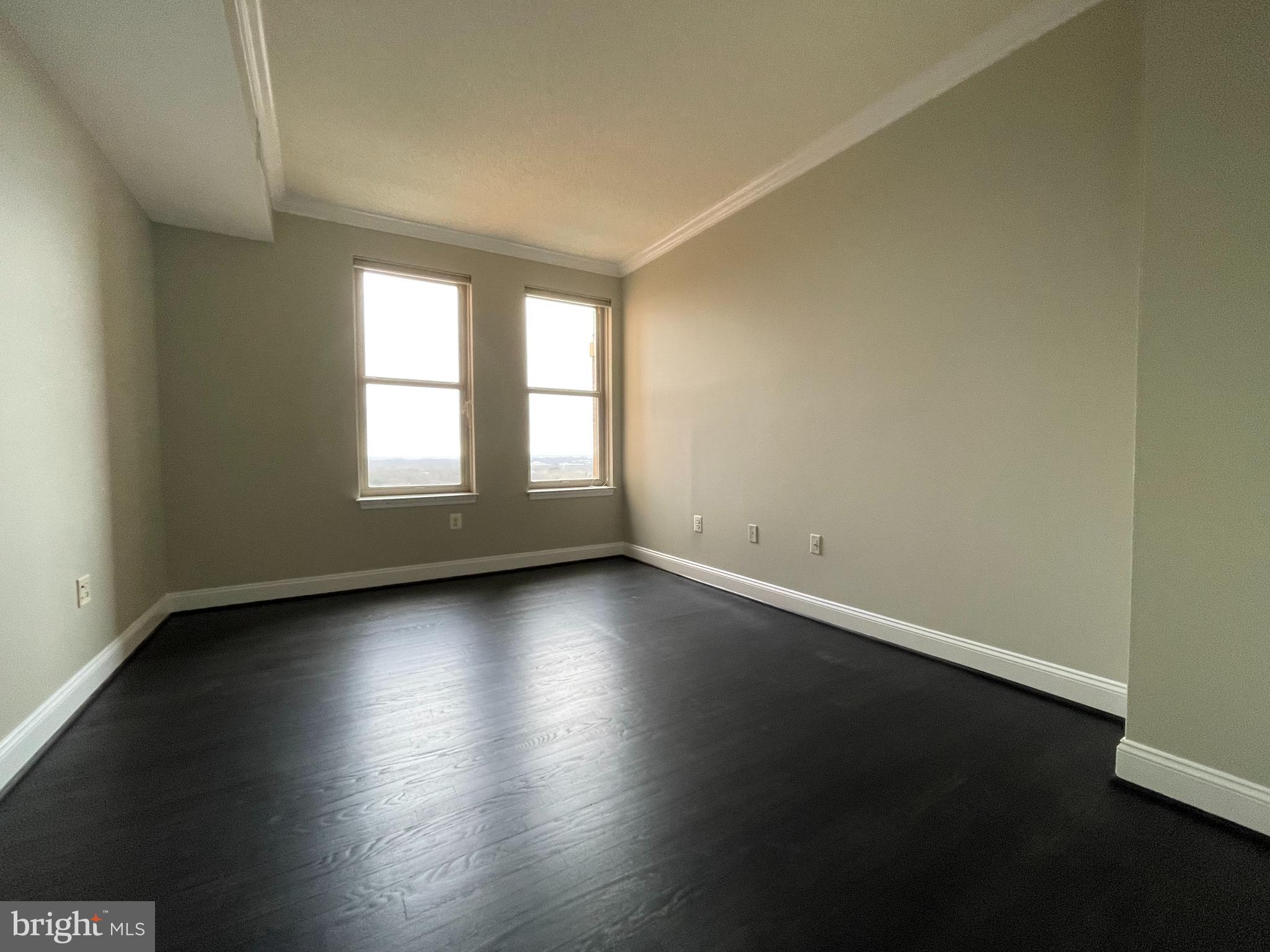 11776 Stratford House Place, Unit 1205 Reston, VA 20190 - Photo 10 of 16 an empty room with wooden floor and windows