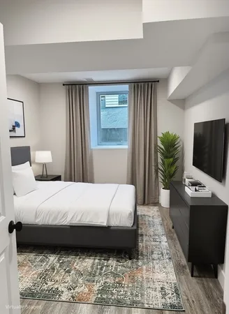 a bedroom with a large bed and a flat screen tv