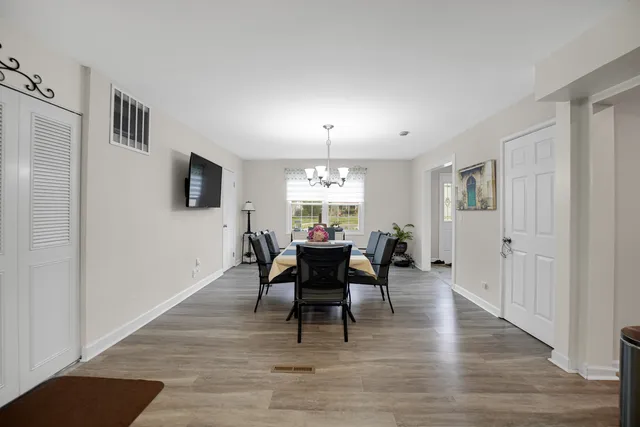 a view of a a dining room with furniture window and wooden floor