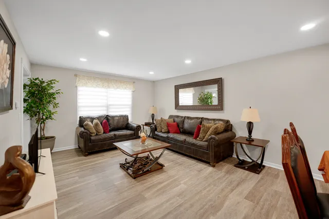 a living room with furniture a window and a wooden floor