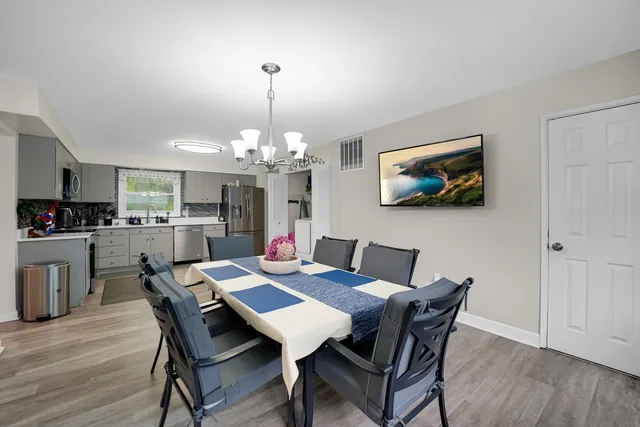 a view of a dining room with furniture wooden floor and chandelier