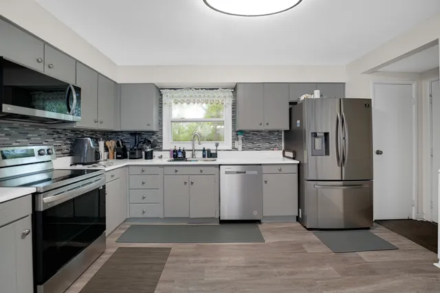 a kitchen with a sink cabinets stainless steel appliances and a window