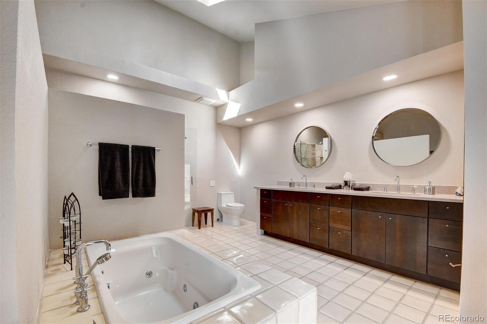 574 Spring Ranch Drive Golden, CO 80401 - Photo 20 of 40 a spacious bathroom with a granite countertop sink a mirror and bathtub
