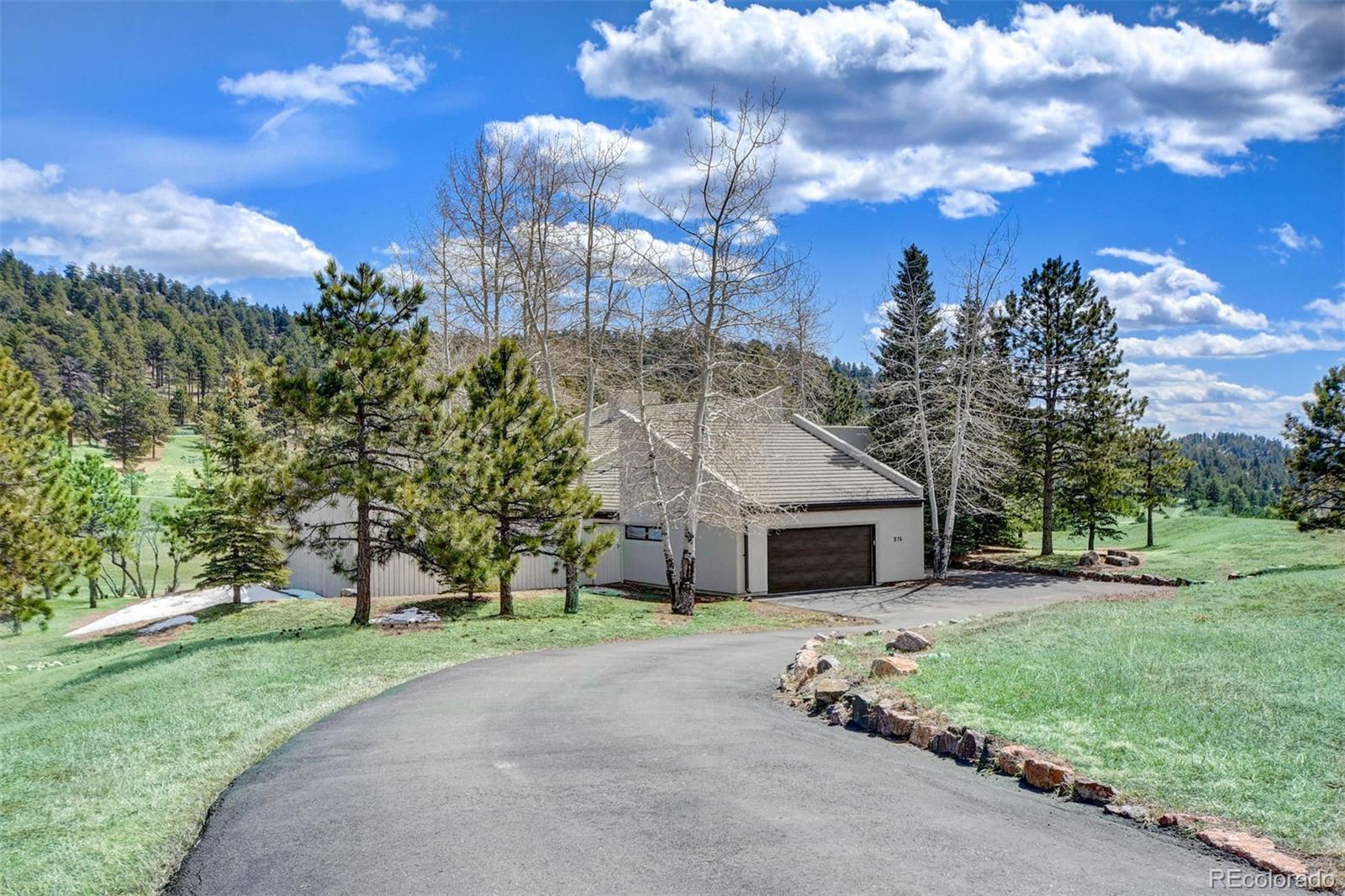 574 Spring Ranch Drive Golden, CO 80401 - Photo 2 of 40 a front view of a house with a yard and garage