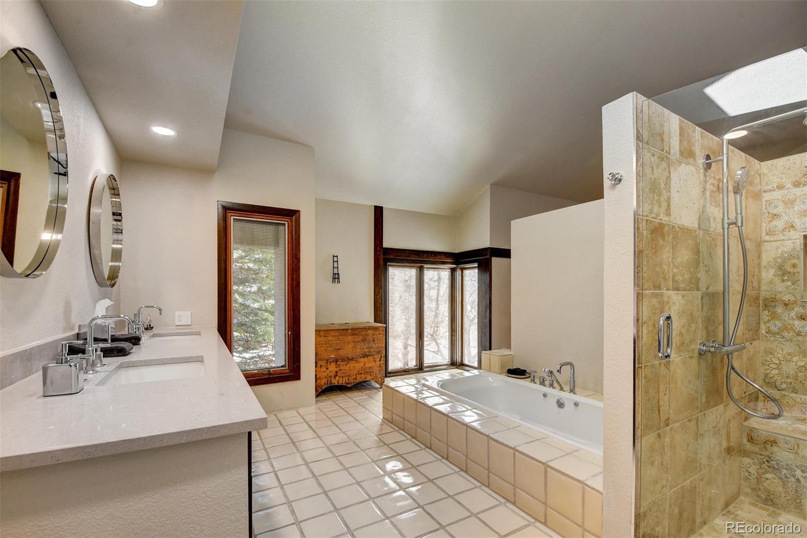 574 Spring Ranch Drive Golden, CO 80401 - Photo 21 of 40 a spacious bathroom with a bathtub sink and mirror