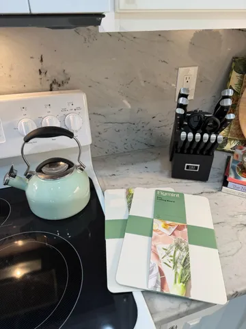 a kitchen with white cabinets and white appliances