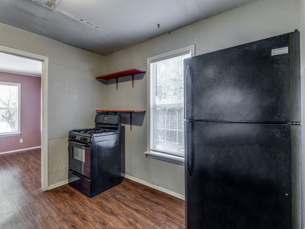 1136 Garland Avenue Austin, TX 78721 - Photo 14 of 24 a kitchen with granite countertop a refrigerator and a stove top oven