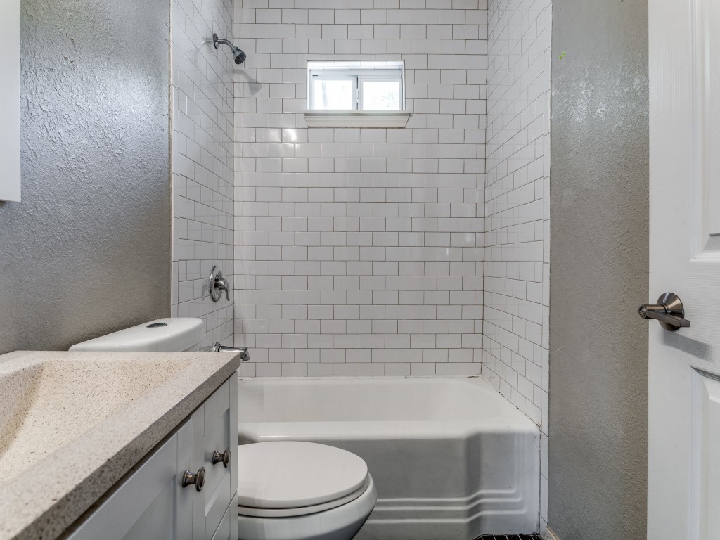 1136 Garland Avenue Austin, TX 78721 - Photo 7 of 24 a bathroom with a granite countertop bathtub shower sink vanity and toilet