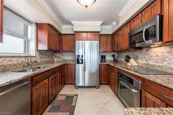 a kitchen with stainless steel appliances granite countertop a refrigerator a stove top oven a sink and dishwasher