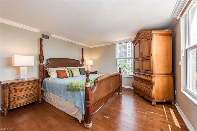 a bedroom with a bed wooden floor and window