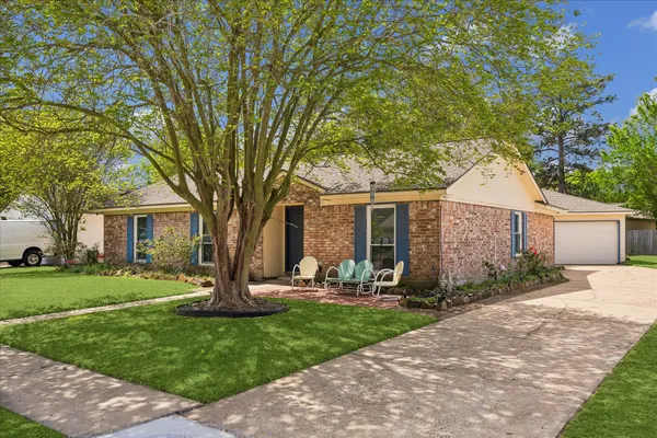 a front view of a house with garden and trees