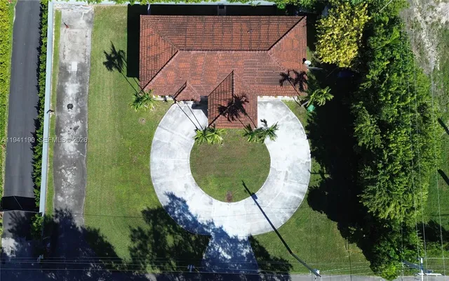 an aerial view of a house with a garden and trees