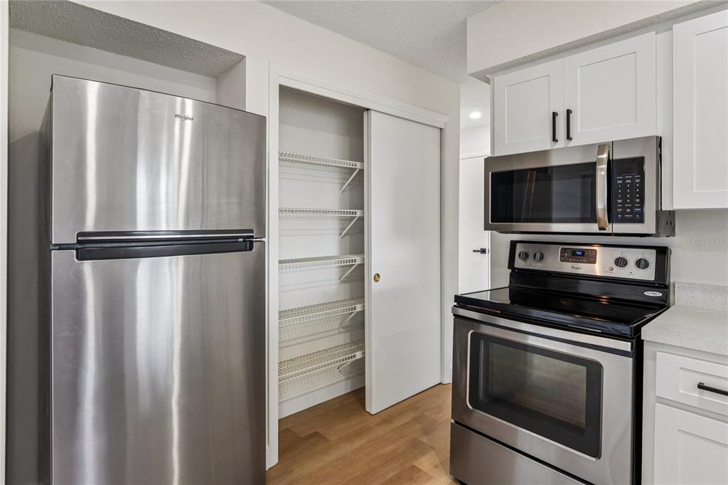 10194 Gamewell Street Spring Hill, FL 34608 - Photo 11 of 36 a kitchen with cabinets and stainless steel appliances