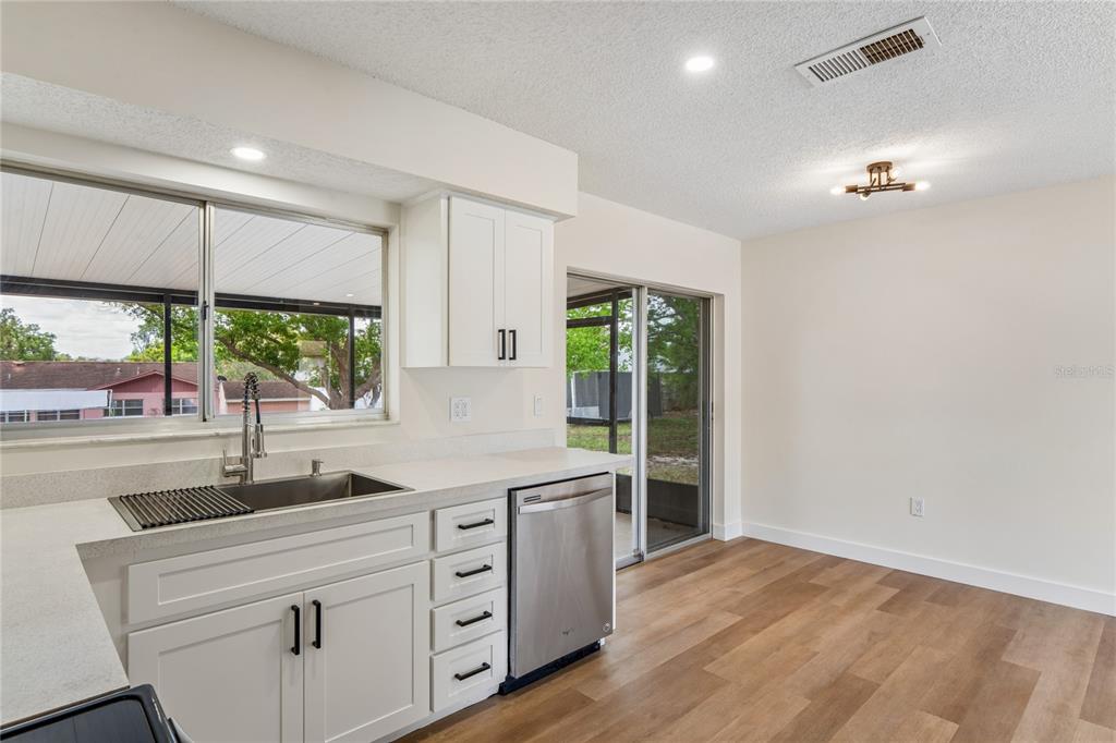 10194 Gamewell Street Spring Hill, FL 34608 - Photo 12 of 36 a kitchen with a large window appliances and cabinets