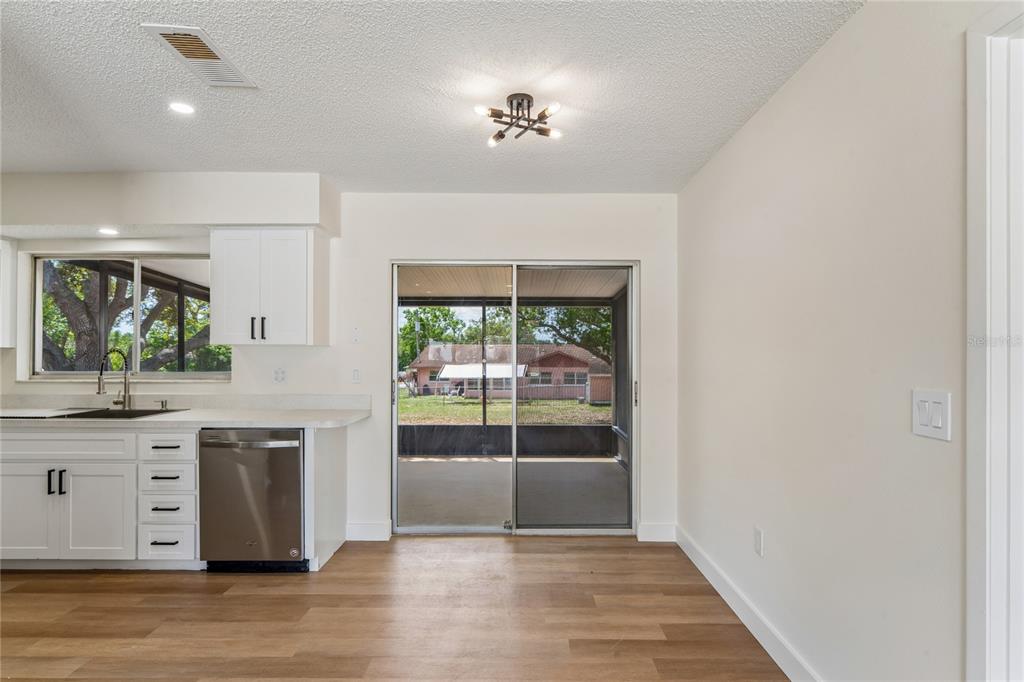 10194 Gamewell Street Spring Hill, FL 34608 - Photo 14 of 36 a kitchen with granite countertop a stove and a wooden floors