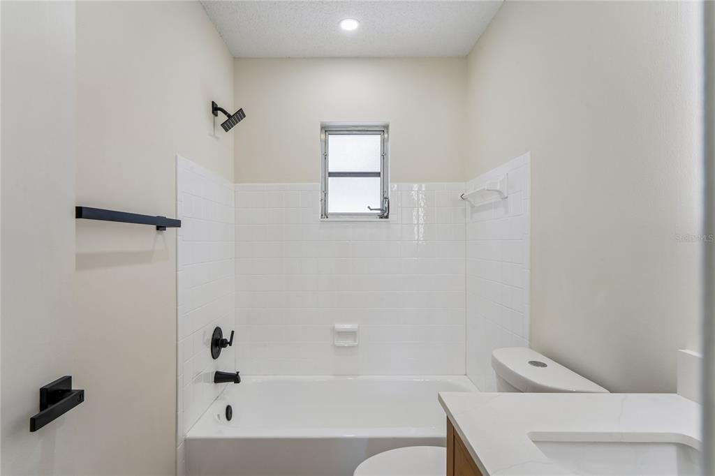 10194 Gamewell Street Spring Hill, FL 34608 - Photo 19 of 36 a bathroom with a bathtub a toilet and a shower