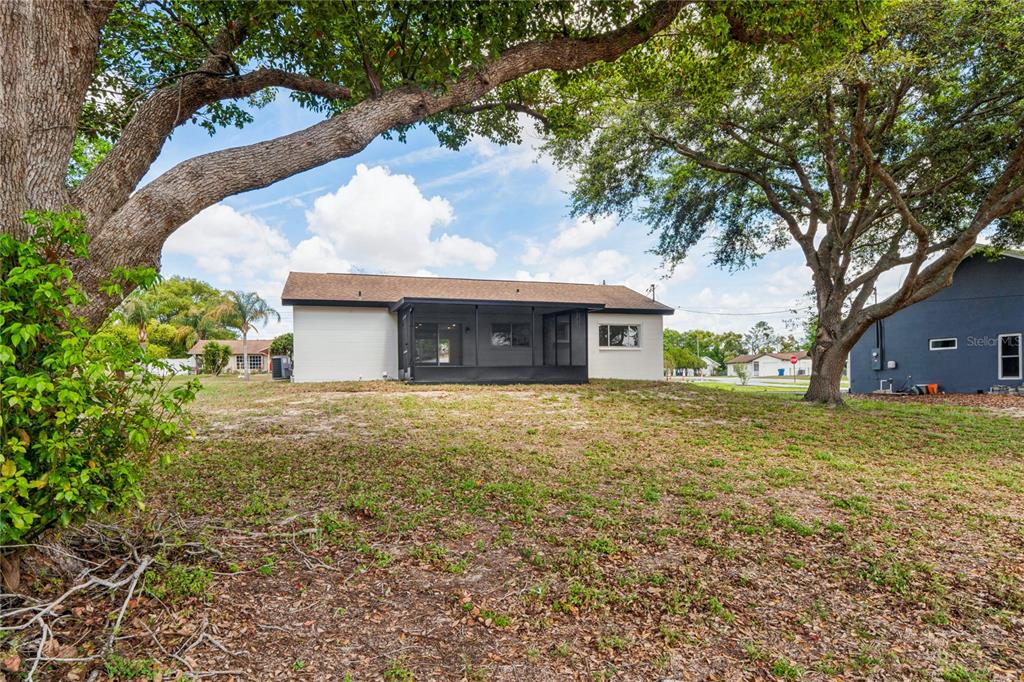 10194 Gamewell Street Spring Hill, FL 34608 - Photo 27 of 36 a front view of a house with a garden and tree