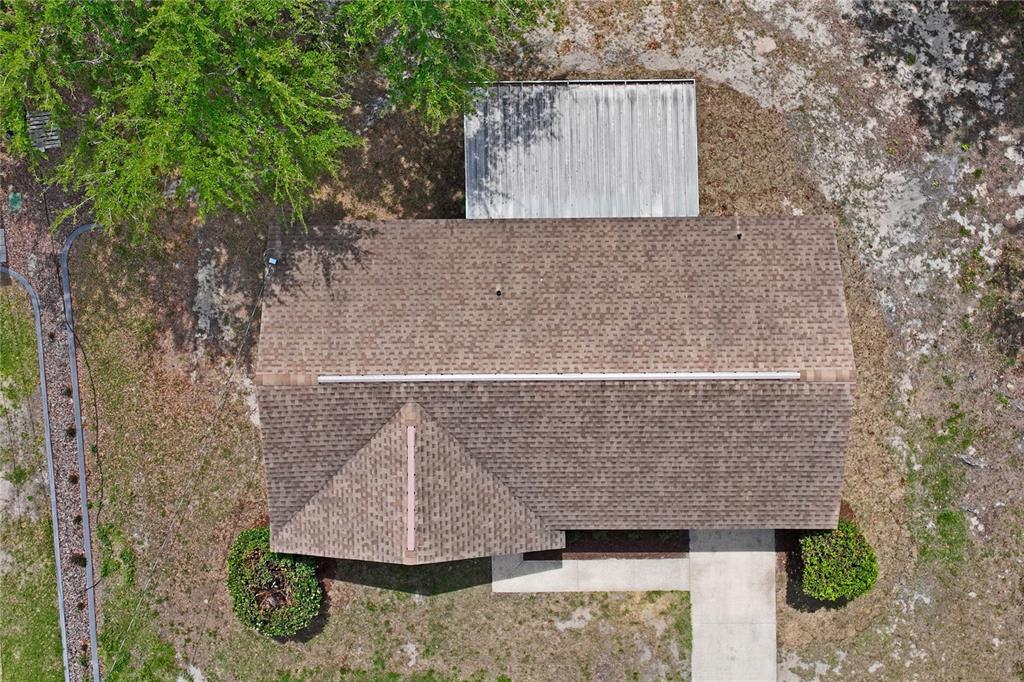 10194 Gamewell Street Spring Hill, FL 34608 - Photo 35 of 36 a stone house with a yard and large trees