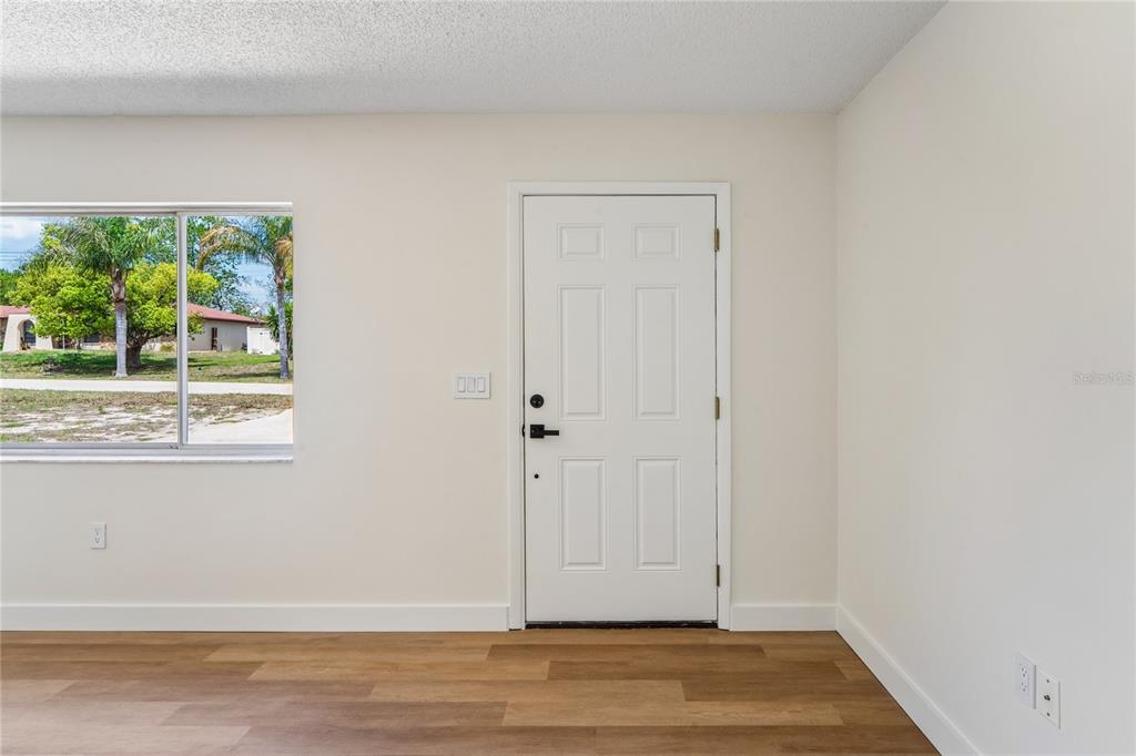 10194 Gamewell Street Spring Hill, FL 34608 - Photo 4 of 36 a view of an empty room with wooden floor and a window