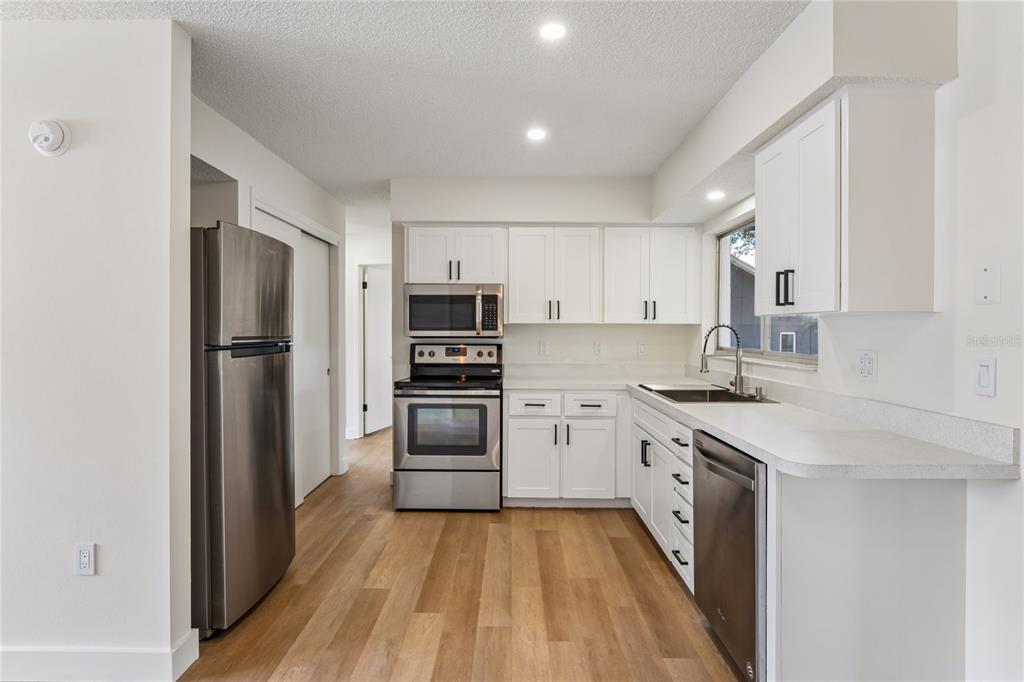 10194 Gamewell Street Spring Hill, FL 34608 - Photo 8 of 36 a kitchen with stainless steel appliances a refrigerator stove and sink