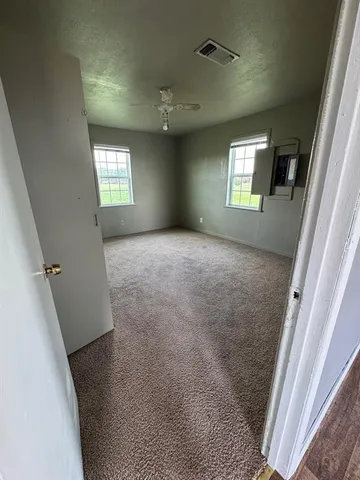 an empty room with windows and mirror