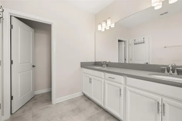 a bathroom with double sink and a mirror