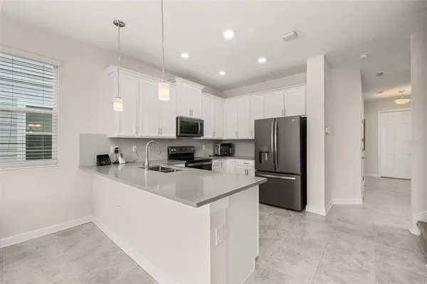 a kitchen with refrigerator a sink and a stove