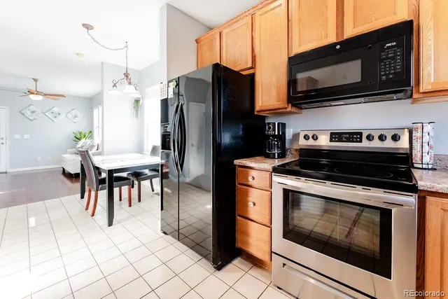 a kitchen with stainless steel appliances kitchen island granite countertop a stove a microwave and a dining table