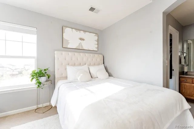 a large bed sitting in a bedroom next to a window