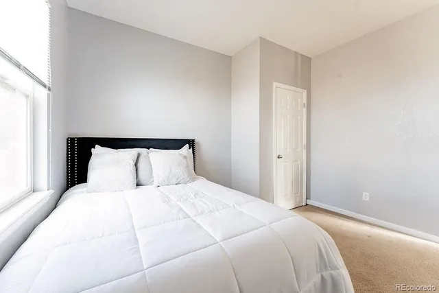 a large bed in a bedroom next to a window