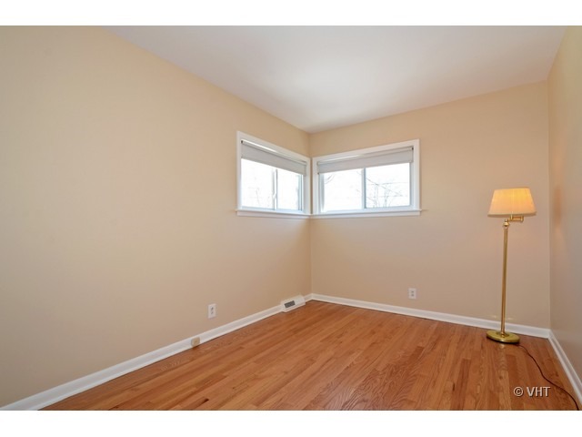 8543 East Prairie Road Skokie, IL 60076 - Photo 8 of 9 an empty room with wooden floor and windows