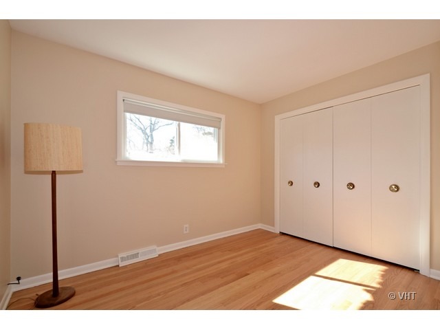8543 East Prairie Road Skokie, IL 60076 - Photo 9 of 9 a view of an empty room with wooden floor and a window