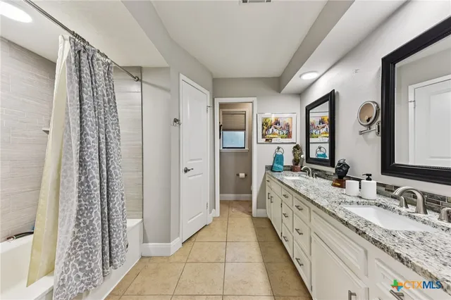 a spacious bathroom with a granite countertop sink and a mirror