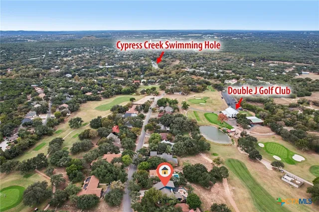 an aerial view of residential houses with city and green space