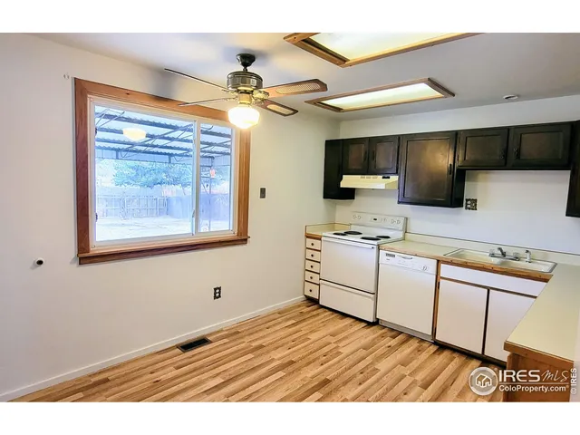 a kitchen with stainless steel appliances granite countertop a sink cabinets and wooden floor