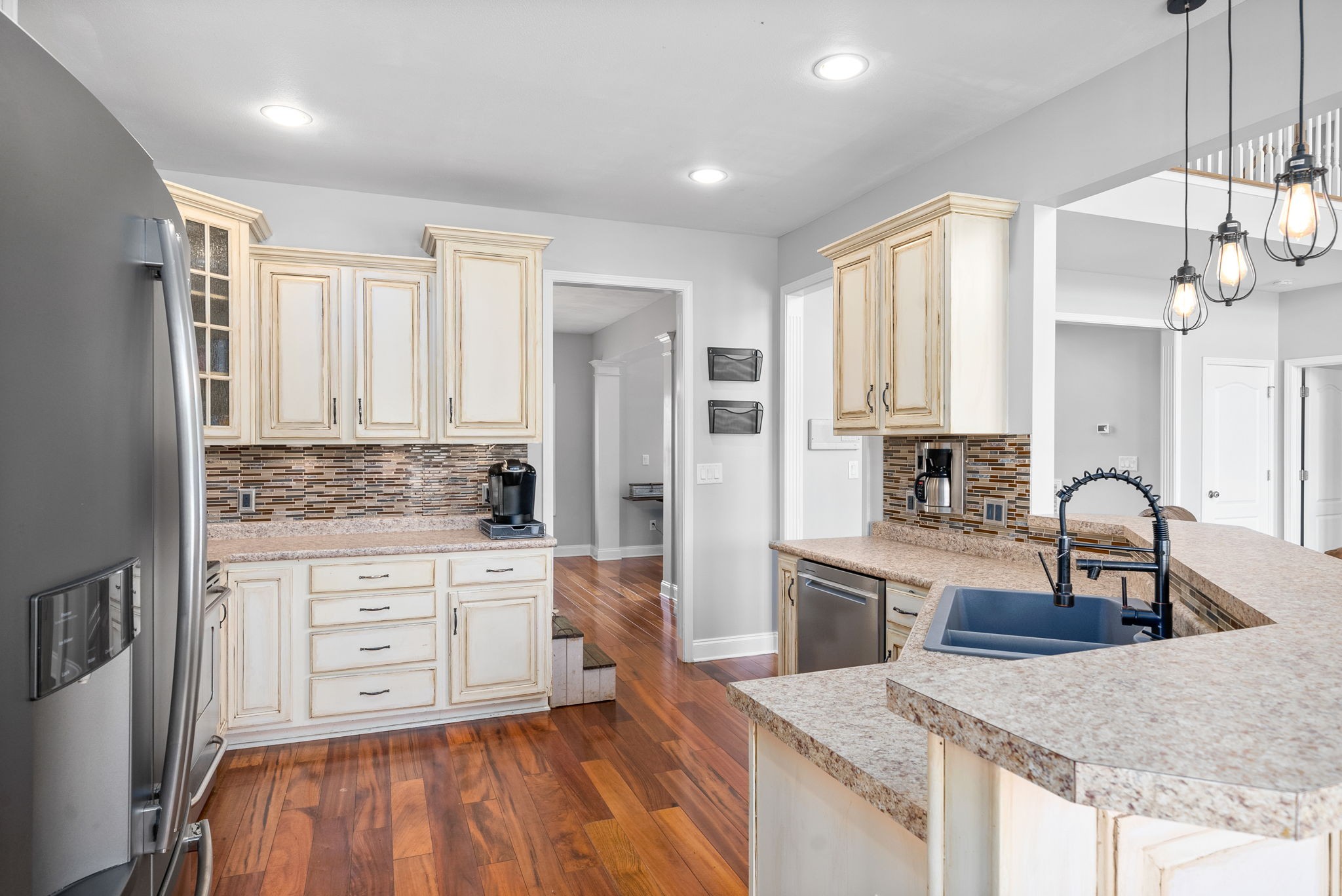 4555 Pineywoods Road Adams, TN 37010 - Photo 14 of 55 a kitchen with stainless steel appliances granite countertop a stove top oven a sink dishwasher and white cabinets with wooden floor