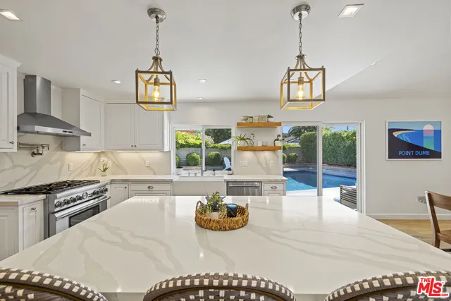 a kitchen with stainless steel appliances granite countertop a stove and white cabinets