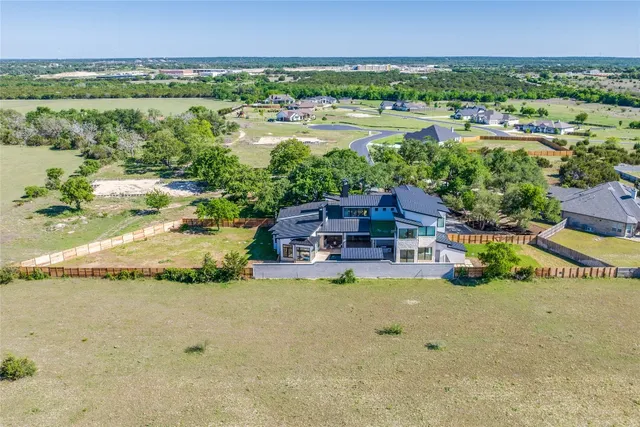 an aerial view of residential houses with outdoor space and swimming pool