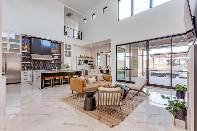 a living room with furniture a flat screen tv and kitchen view