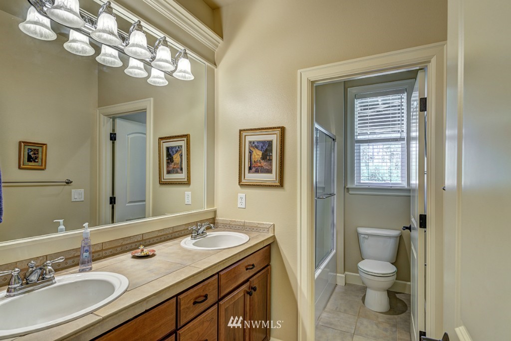 5370 Northeast 17th Street Renton, WA 98059 - Photo 22 of 25 a bathroom with a granite countertop toilet a sink and a mirror