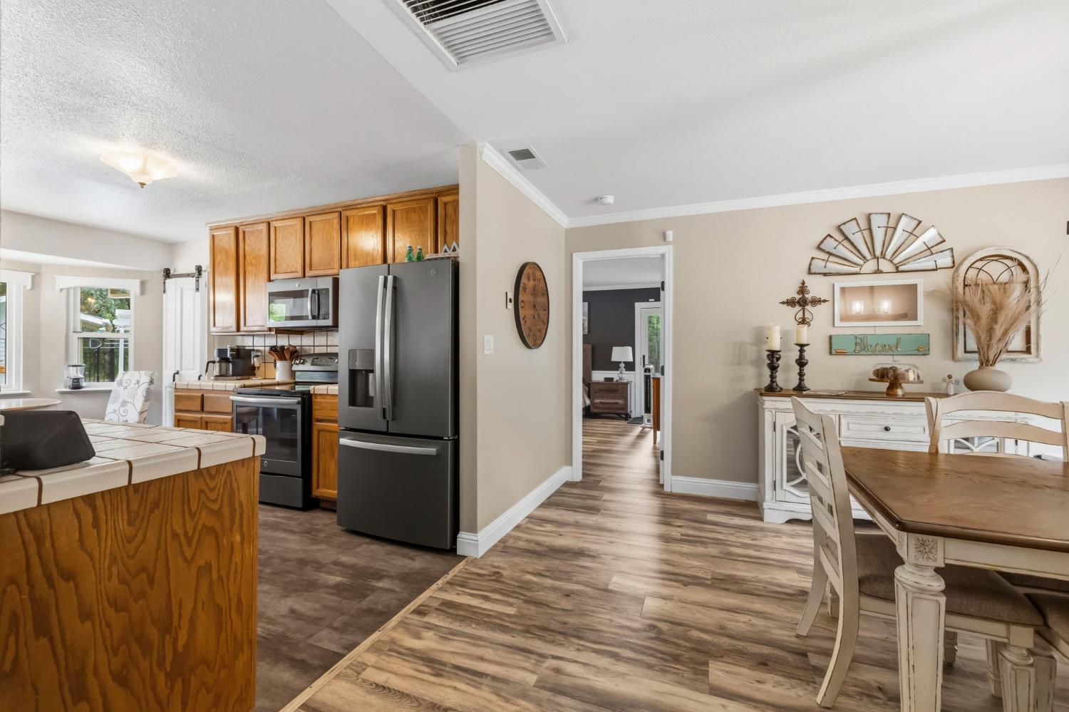 11460 Racetrack Road Sonora, CA 95370 - Photo 8 of 46 a kitchen with stainless steel appliances granite countertop a refrigerator a stove a sink a dining table and chairs with wooden floor