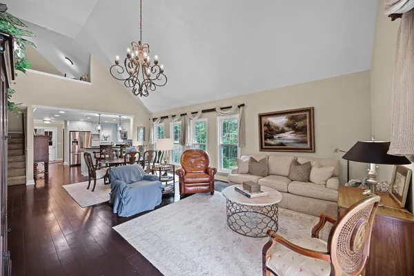 a living room with furniture chandelier and a flat screen tv