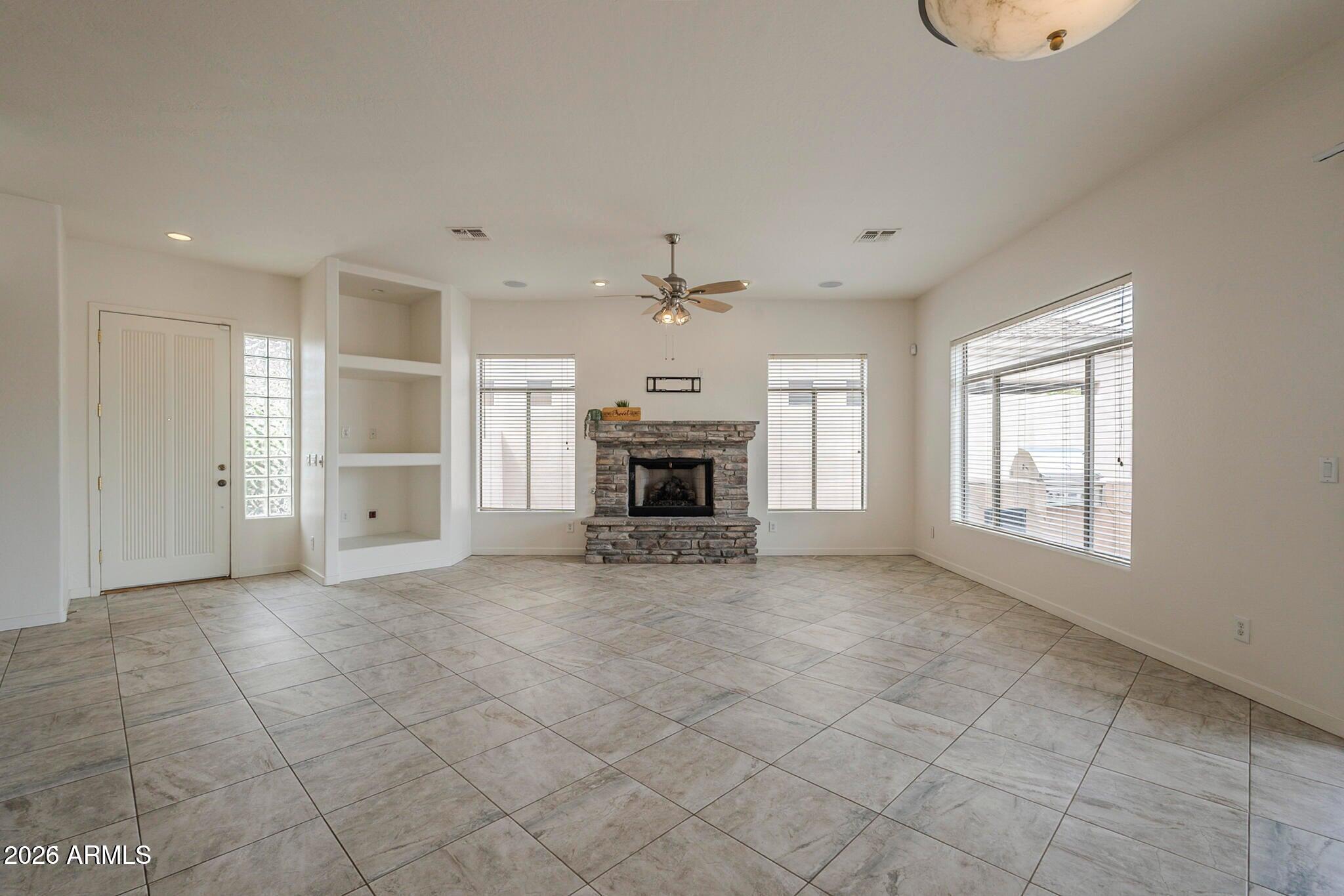 3910 East Carson Road Phoenix, AZ 85042 - Photo 3 of 19 an empty room with fireplace and windows
